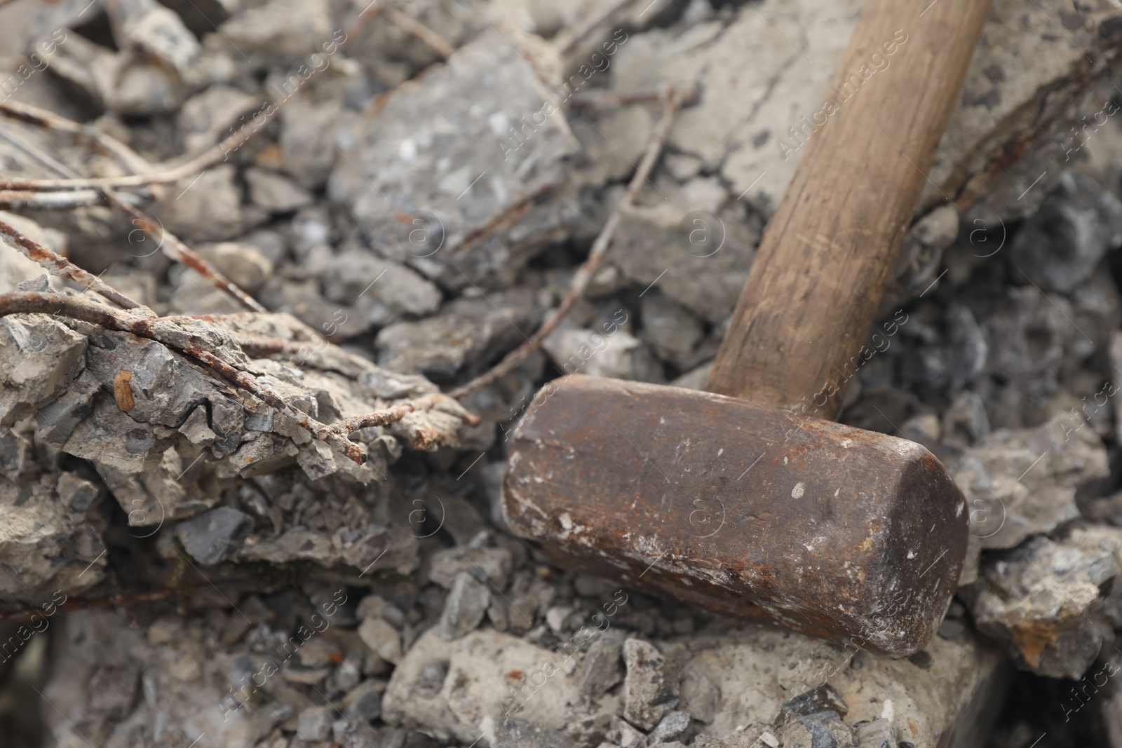 Photo of Sledgehammer on pile of broken stones outdoors, closeup