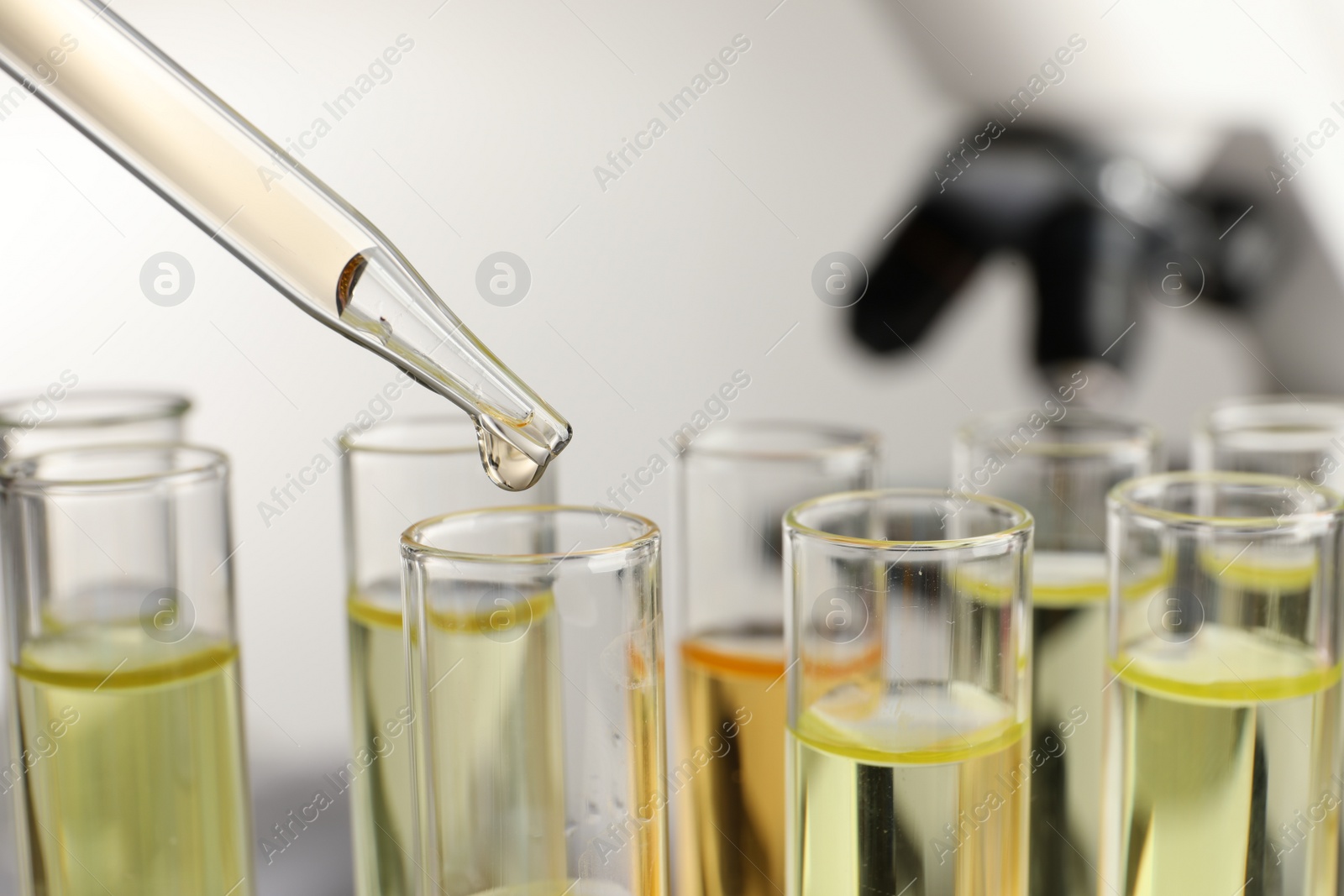 Photo of Dropping urine sample for analysis into tube, closeup