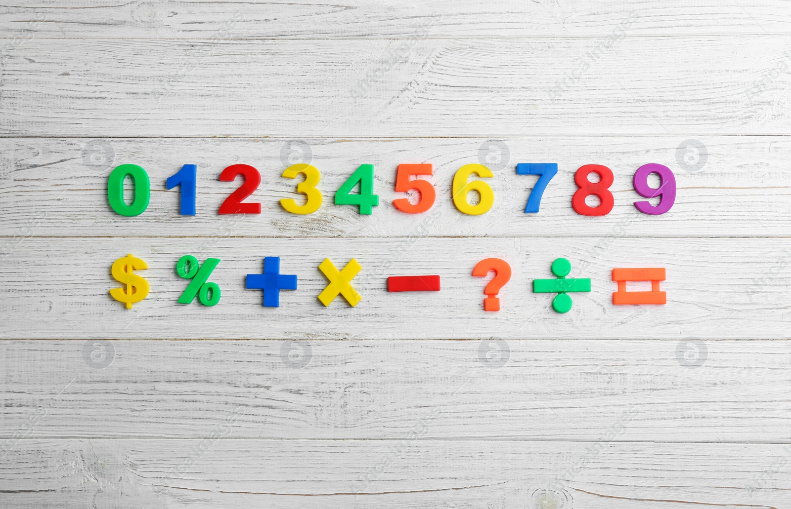 Photo of Colorful magnetic numbers and math symbols on white wooden background, flat lay