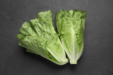 Photo of Fresh green romaine lettuces on dark table, flat lay
