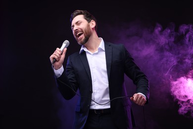 Emotional man with microphone singing in neon lights