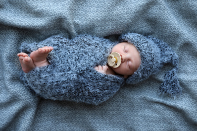 Cute newborn baby sleeping on blanket, top view