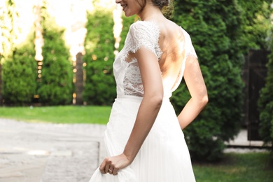 Photo of Gorgeous bride in beautiful wedding dress outdoors, closeup