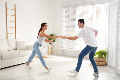 Beautiful young couple dancing in living room
