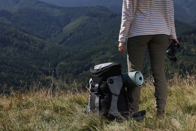 Back view of tourist with hiking equipment and binoculars in mountains, closeup