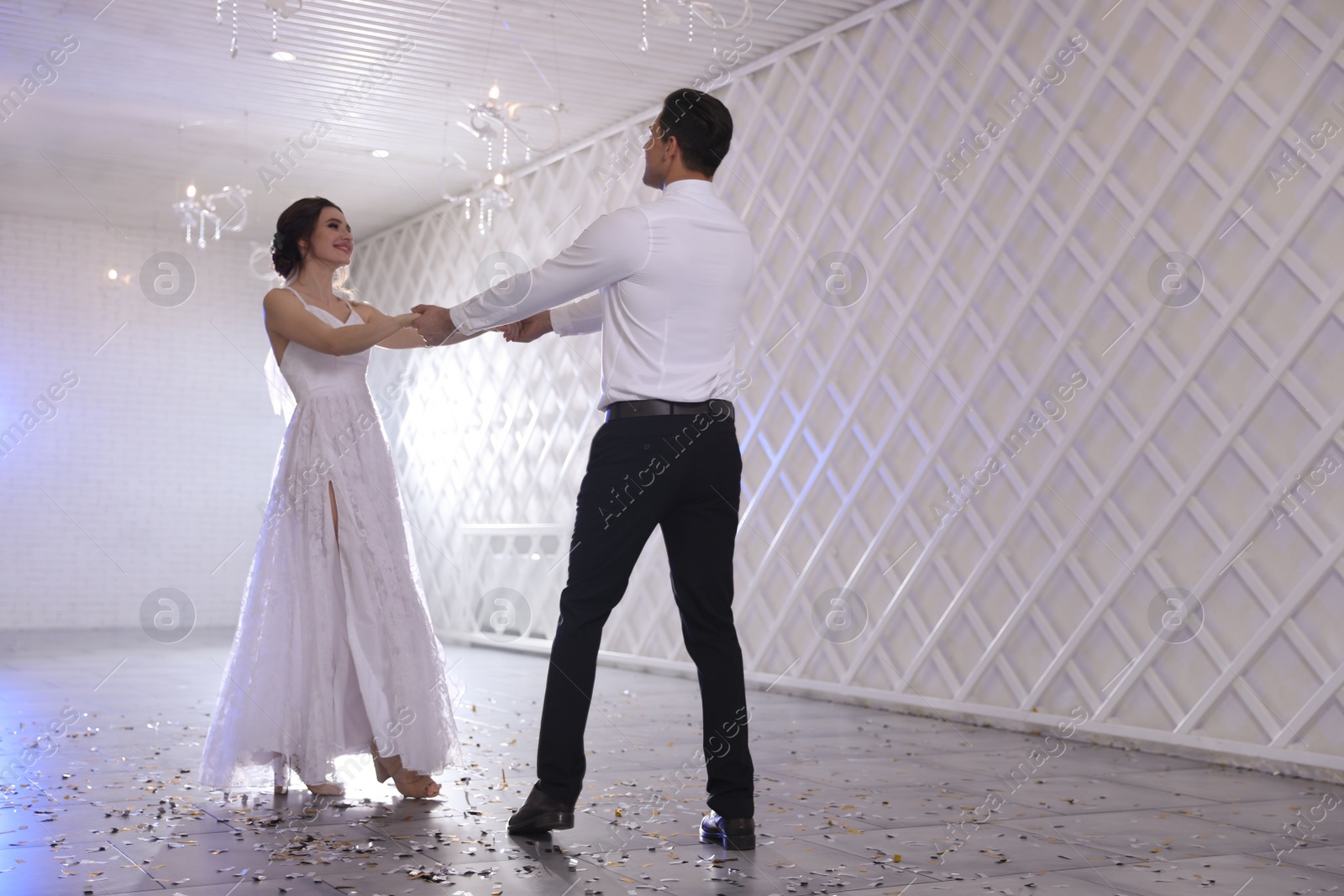 Photo of Happy newlywed couple dancing together in festive hall