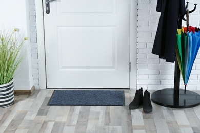 Photo of Hallway interior with mat and clothes stand near door