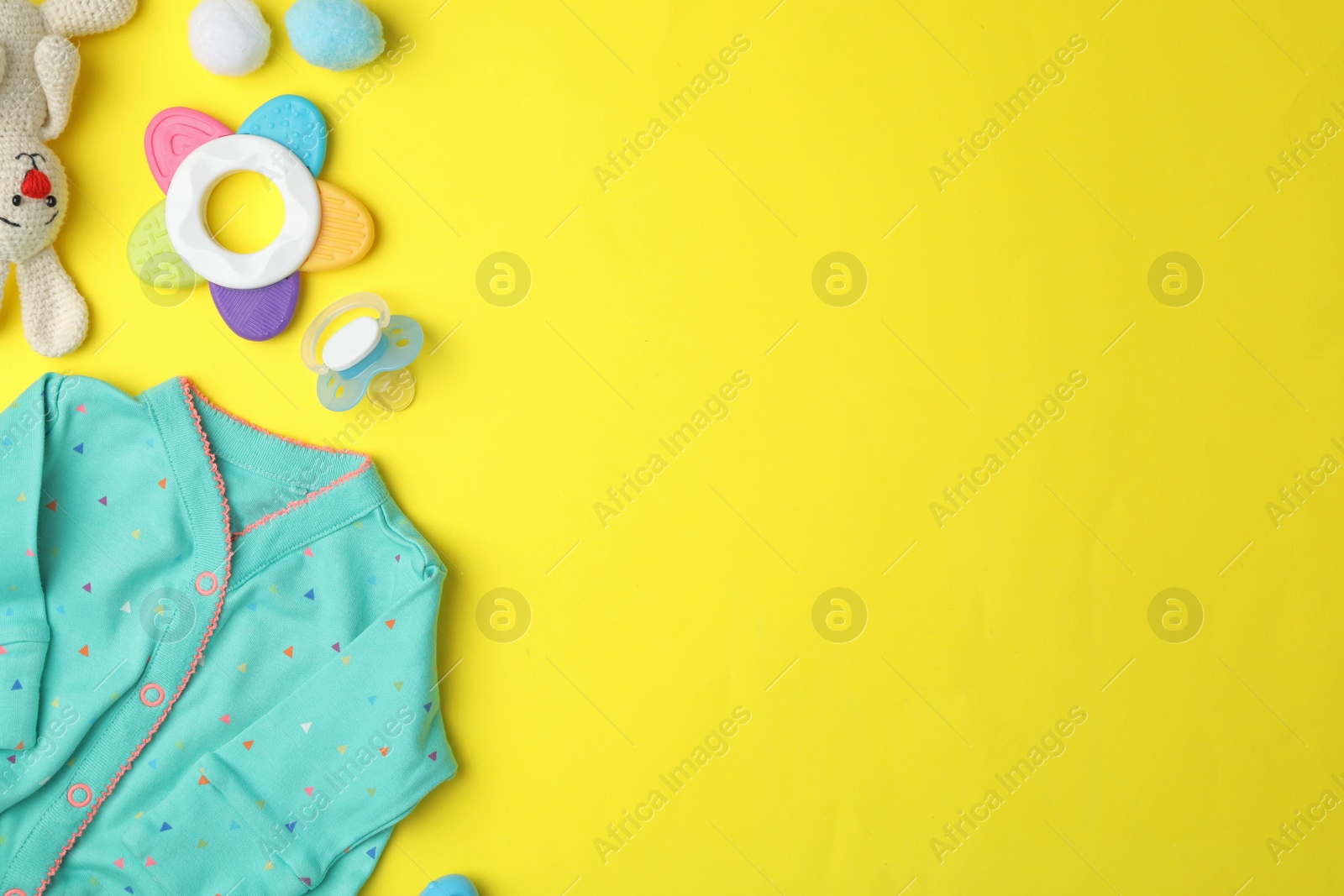 Photo of Flat lay composition with child's clothes and accessories on yellow background, space for text