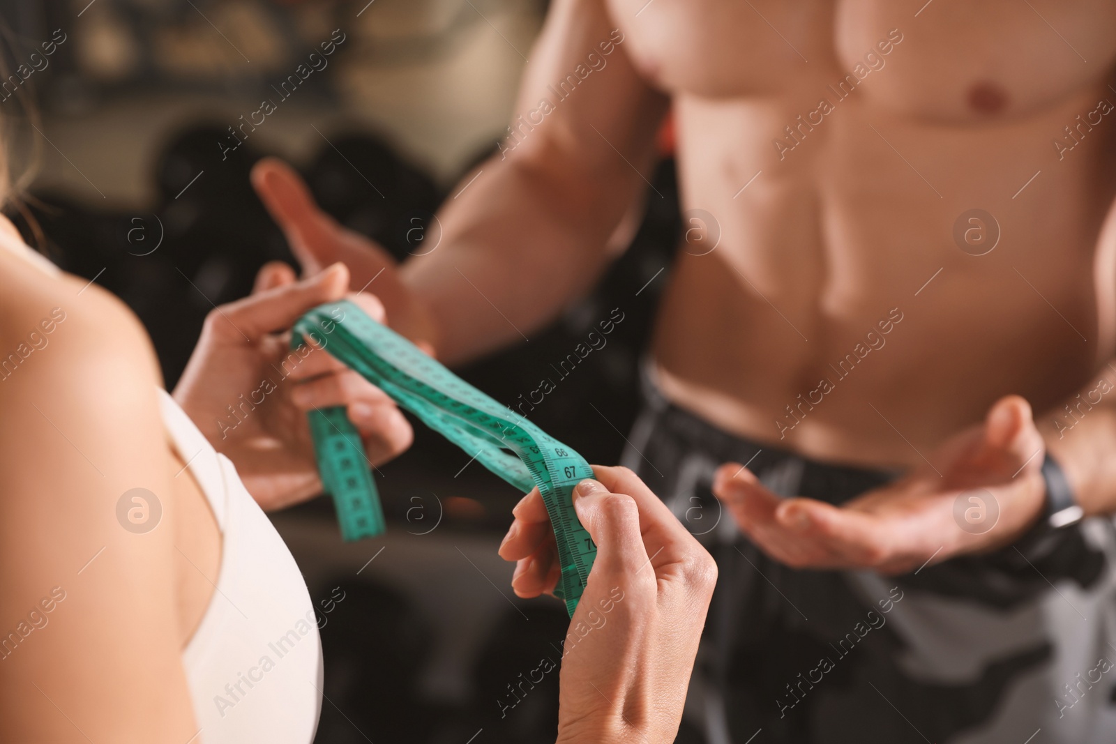 Photo of Trainer having discussion with woman in gym, closeup