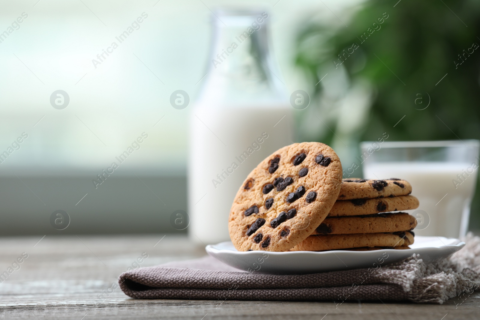 Photo of Delicious chocolate chip cookies on wooden table, space for text