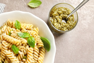 Photo of Plate of delicious basil pesto pasta served for dinner on table, flat lay