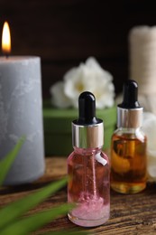Photo of Bottles with essential oils on wooden table. Spa products