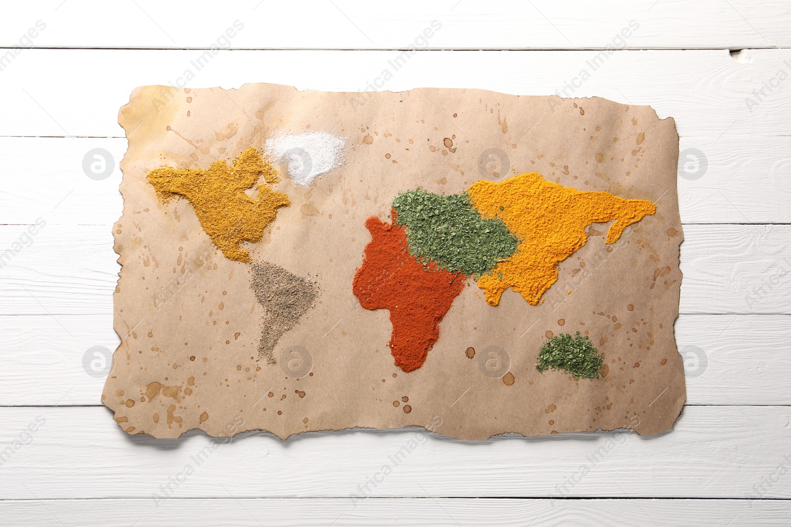 Photo of World map of different spices on white wooden table, top view