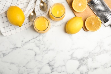 Photo of Delicious lemon curd and fresh fruits on white marble table, flat lay. Space for text