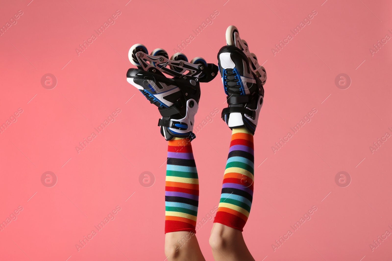 Photo of Woman with roller skates on color background, closeup