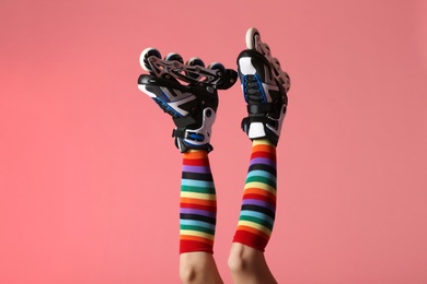 Woman with roller skates on color background, closeup