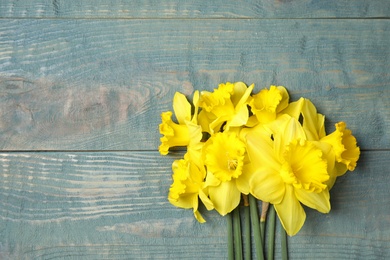 Bouquet of daffodils on wooden background, top view with space for text. Fresh spring flowers