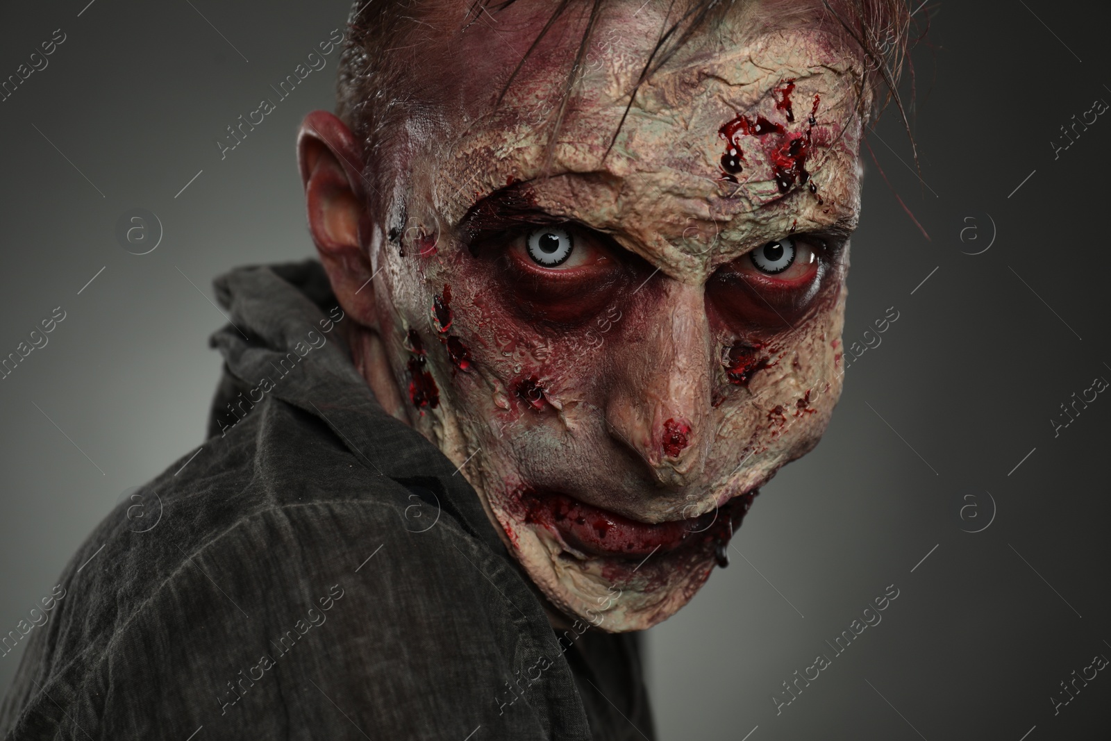 Photo of Scary zombie on dark background, closeup. Halloween monster