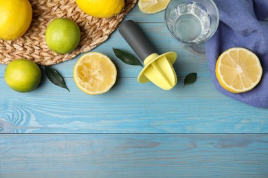 Citrus reamer, fresh lemons and limes on light blue wooden table, flat lay. Space for text