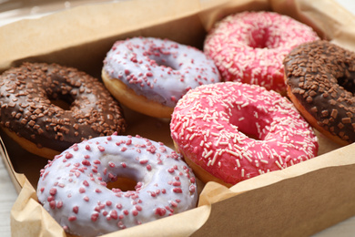 Photo of Sweet delicious glazed donuts in box, closeup