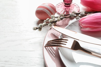 Festive Easter table setting with painted egg on wooden background, closeup. Space for text