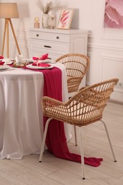 Photo of Color accent table setting. Plates, cutlery and pink napkins in dining room