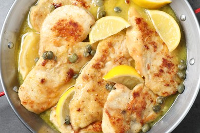 Delicious chicken piccata with lemons in pot, top view