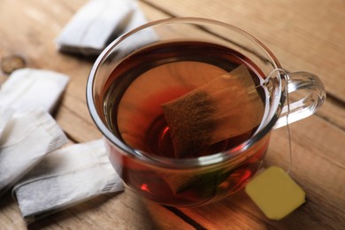 Tea bag in glass cup on wooden table, closeup