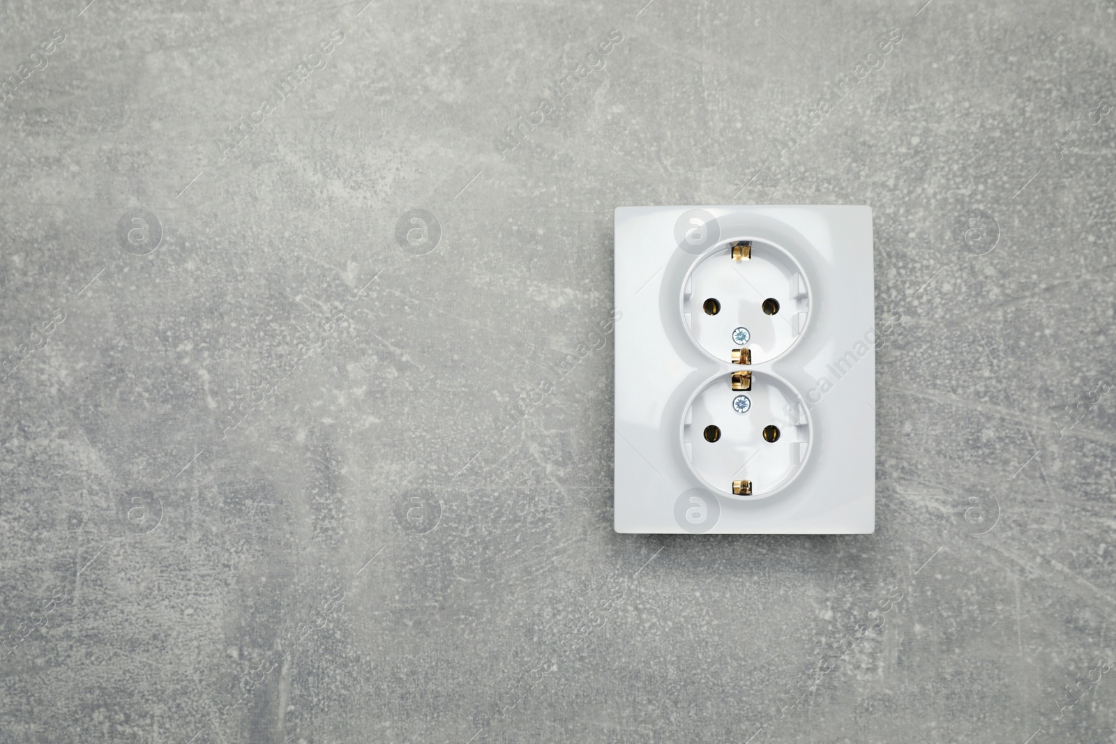 Photo of Modern plastic power socket on grey table, top view. Space for text