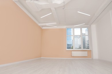 Photo of New empty office room with clean windows and beige walls