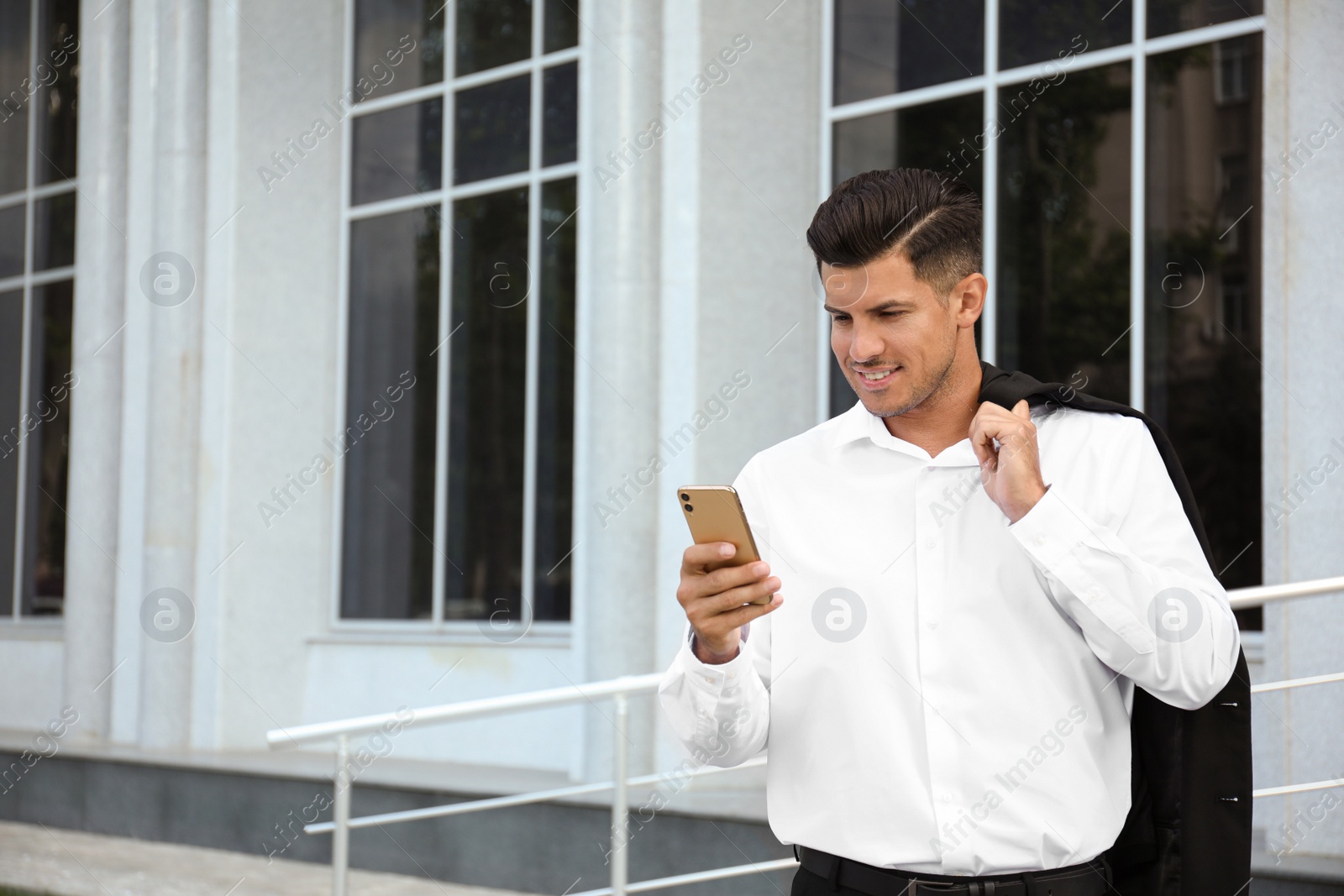 Photo of Handsome man with smartphone on city street