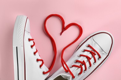 Photo of Pair of trendy sneakers on pink background, flat lay