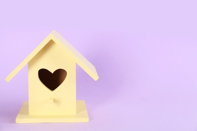 Photo of Beautiful bird house on violet background, space for text