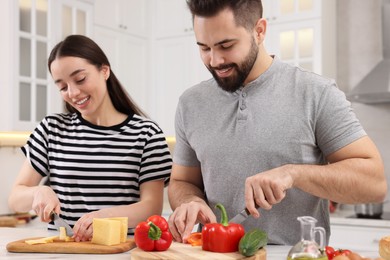 Lovely young couple cooking together in kitchen