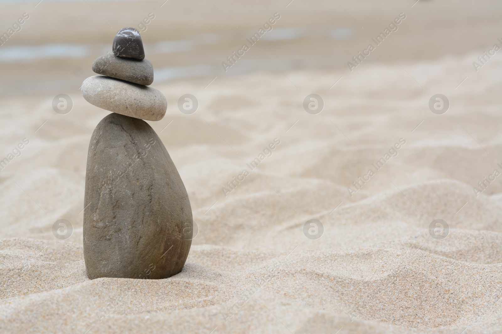 Photo of Stack of stones on beautiful sandy beach, space for text