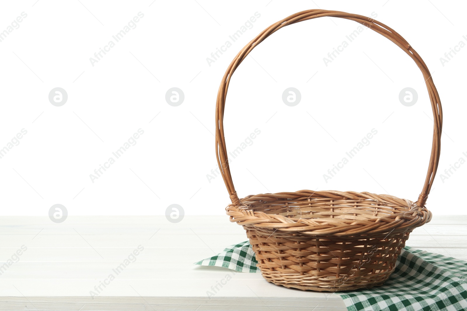 Photo of Empty wicker basket and cloth on wooden table against white background, space for text. Easter holiday