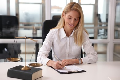 Photo of Smiling lawyer working at table in office