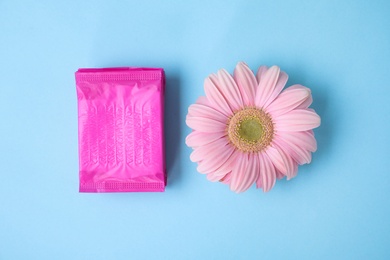 Photo of Flat lay composition with menstrual pads and gerbera flower on color background. Gynecological care