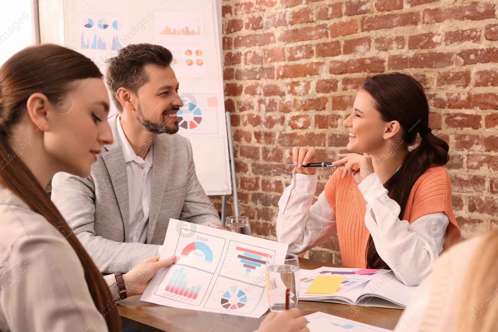 Photo of Team of employees working together in office