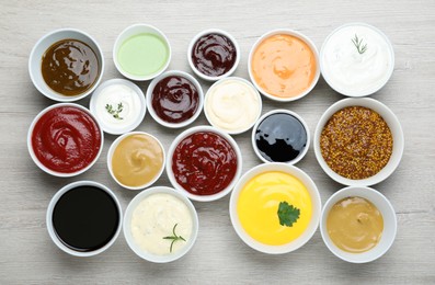 Photo of Many different sauces on white wooden table, flat lay