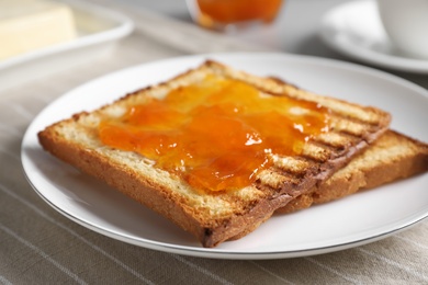 Photo of Tasty toasts with jam served on table, closeup