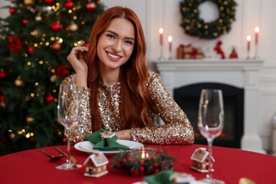 Beautiful young woman at table served for Christmas in room