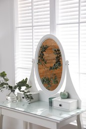 Stylish dressing table decorated with beautiful eucalyptus branches indoors