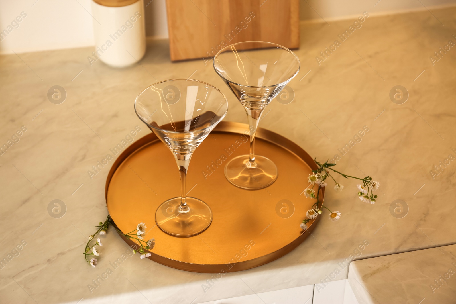Photo of Elegant clean empty martini glasses on light countertop in kitchen