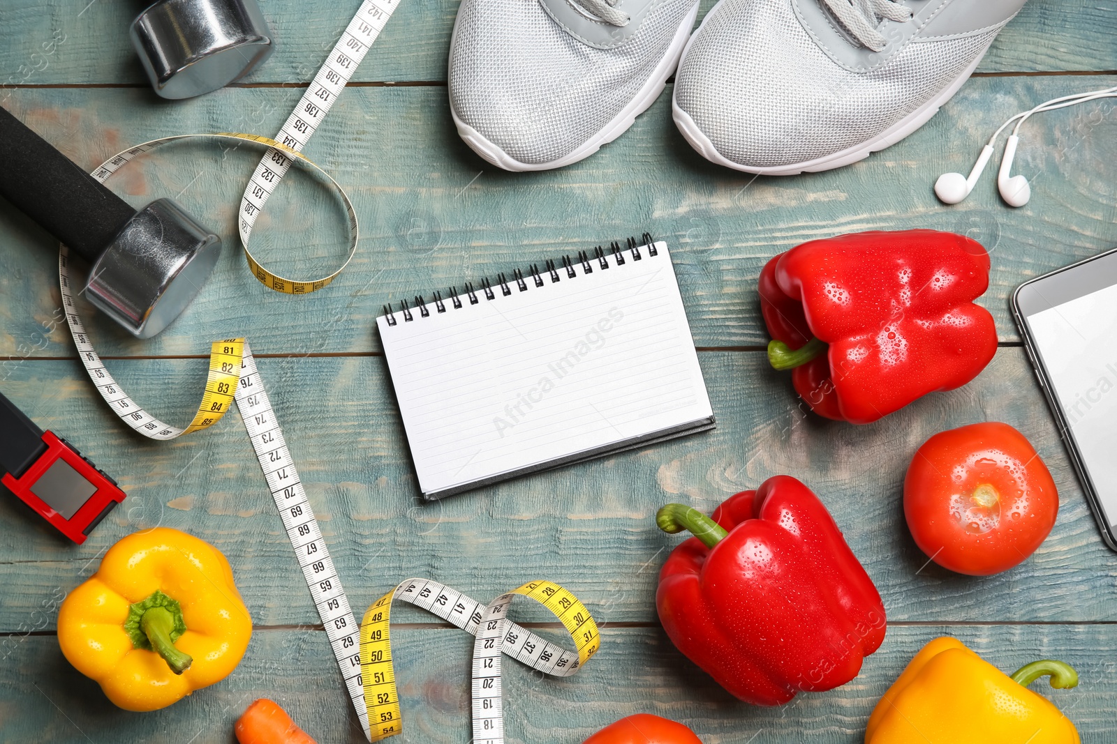 Photo of Flat lay composition with sport items, healthy food, notebook and space for text on wooden background. Weight loss concept