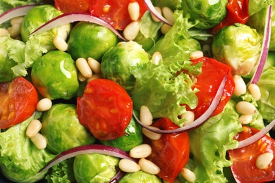 Salad with Brussels sprouts and pine nuts as background, closeup