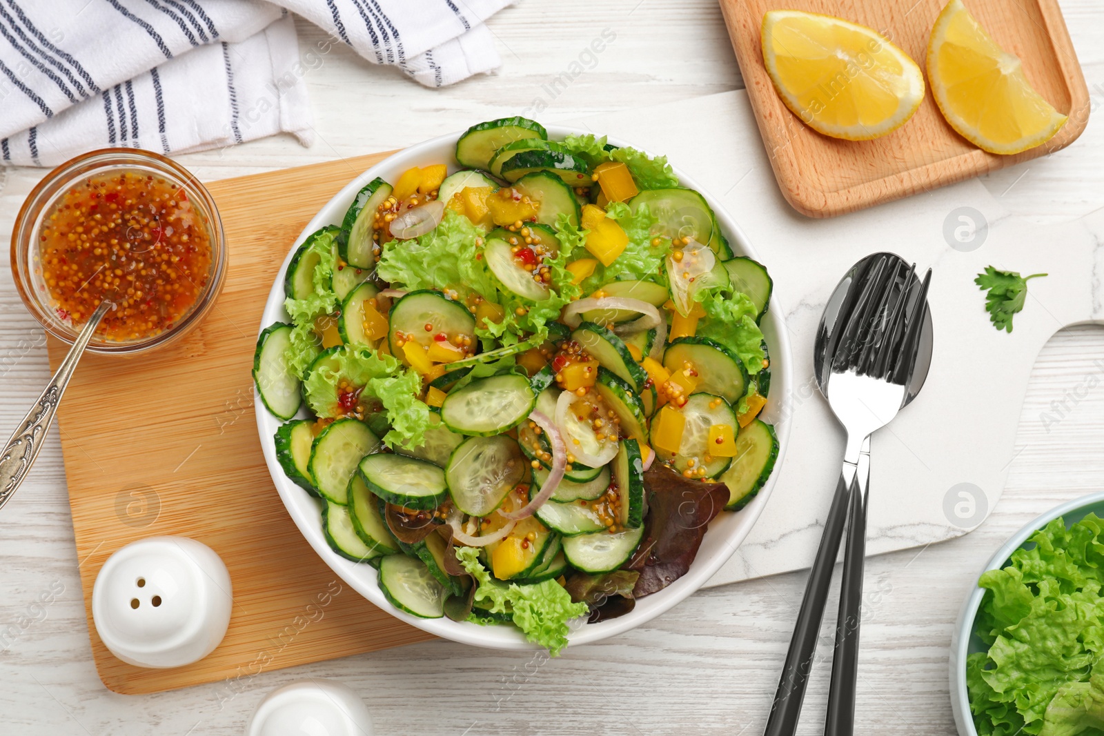 Photo of Flat lay composition with delicious cucumber salad on white wooden table