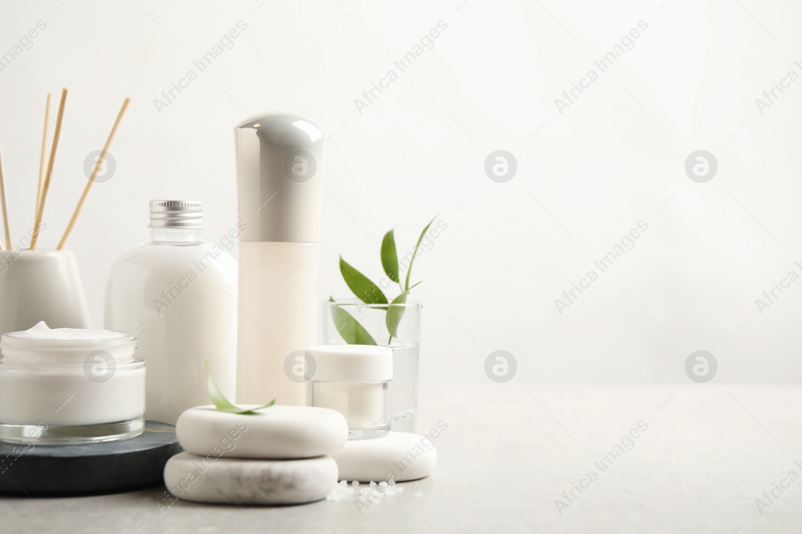 Photo of Composition with skin care products and spa stones on light background, space for text