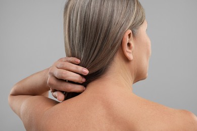 Photo of Mature woman with healthy skin on grey background