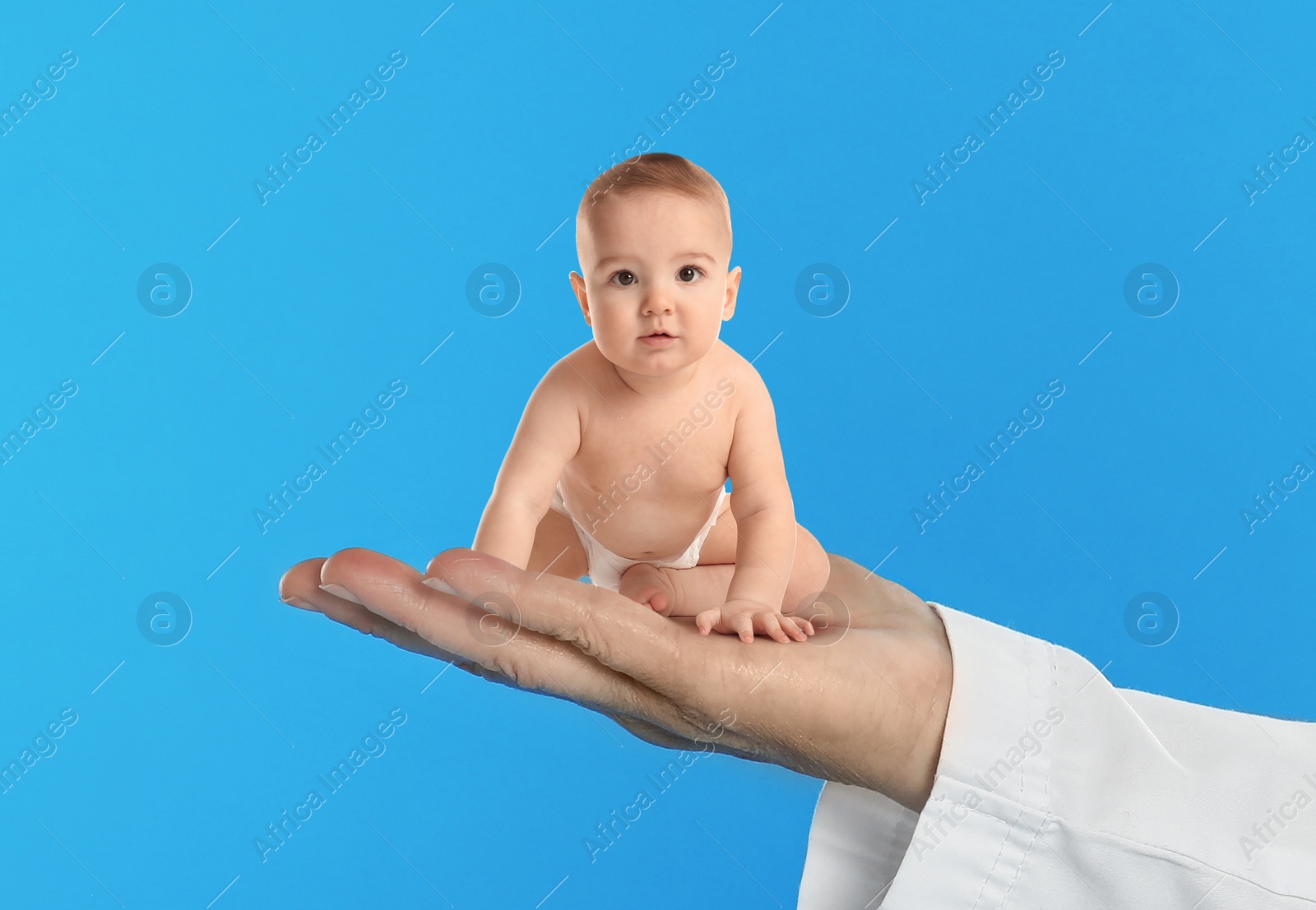 Image of Surrogacy concept. Doctor holding cute little baby on blue background, closeup